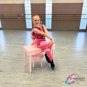 dancer in pink sitting on a prop
